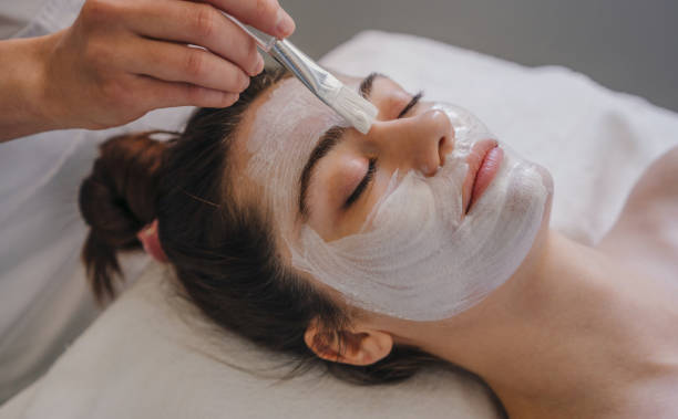 Best cleanser for acne – woman getting facial cream applied with a brush during skincare treatment"